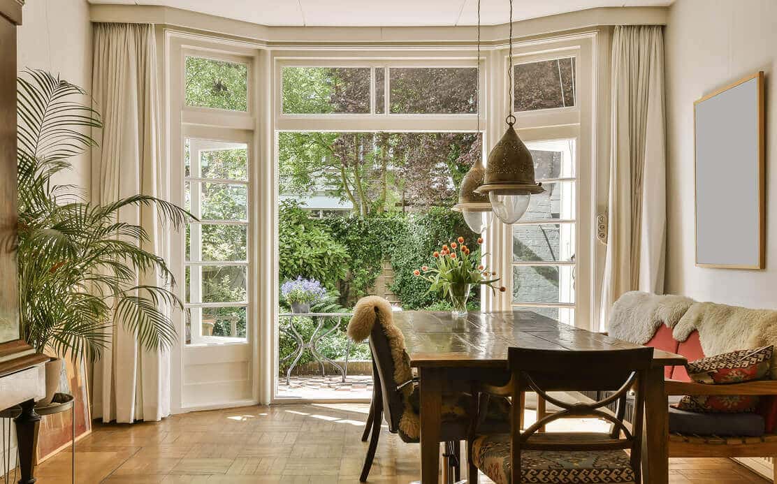 Beautiful dining room with large modern windows overlooking a garden