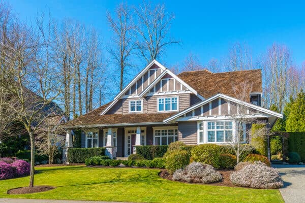 Craftsman home with white-trimmed double-hung windows and manicured lawn