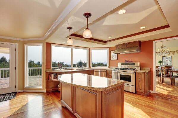 Bright kitchen with large picture windows overlooking a backyard deck