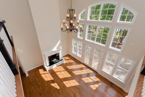 High-ceiling living room with a massive arched window wall and fireplace