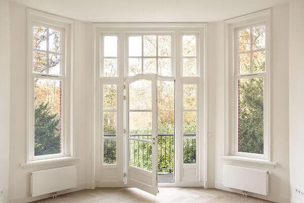 Elegant white bay window with an integrated glass door leading to a balcony